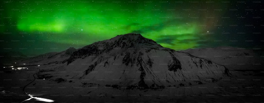 uma montanha coberta de neve sob uma luz verde