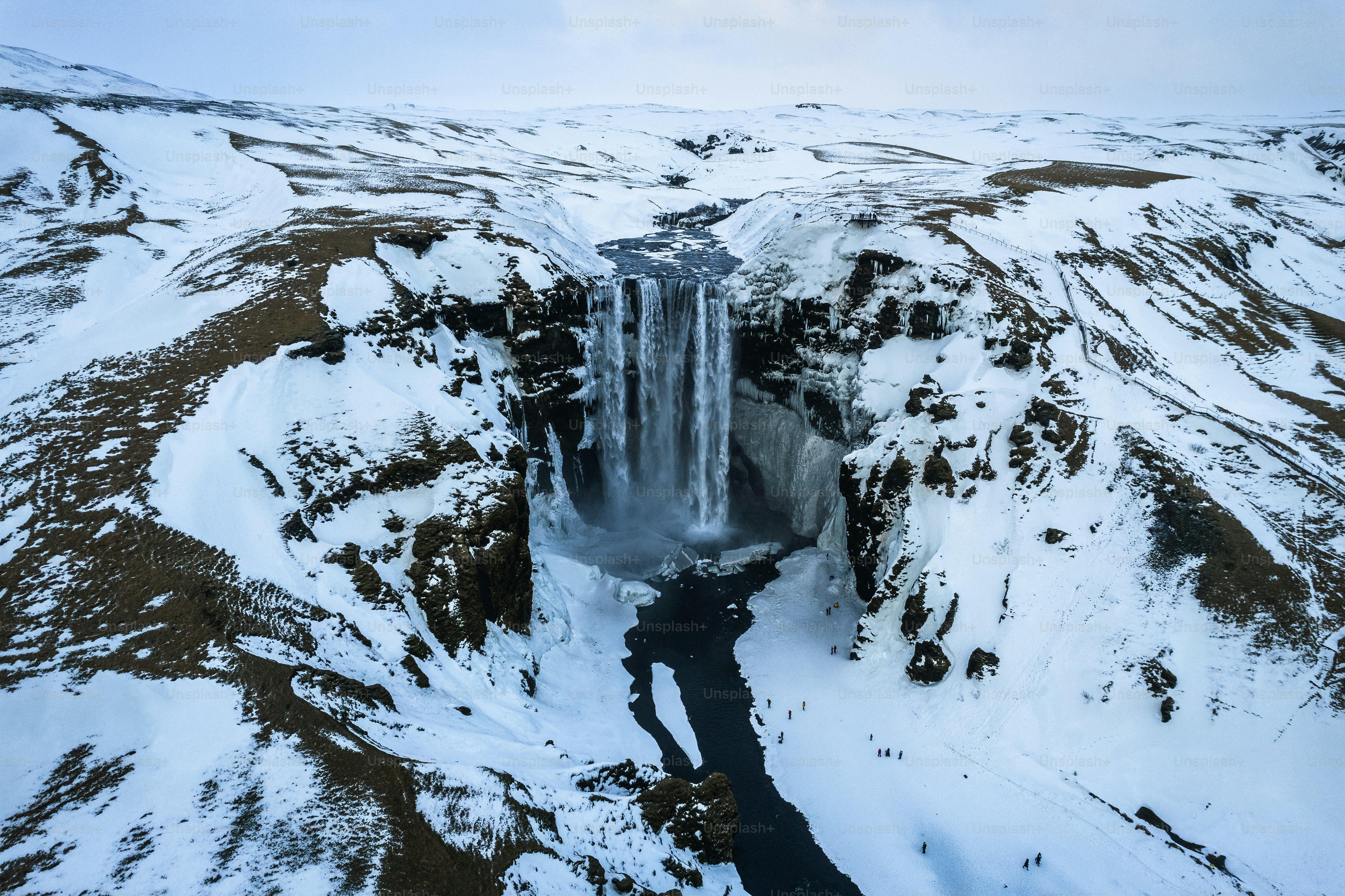una grande cascata nel mezzo di una montagna innevata