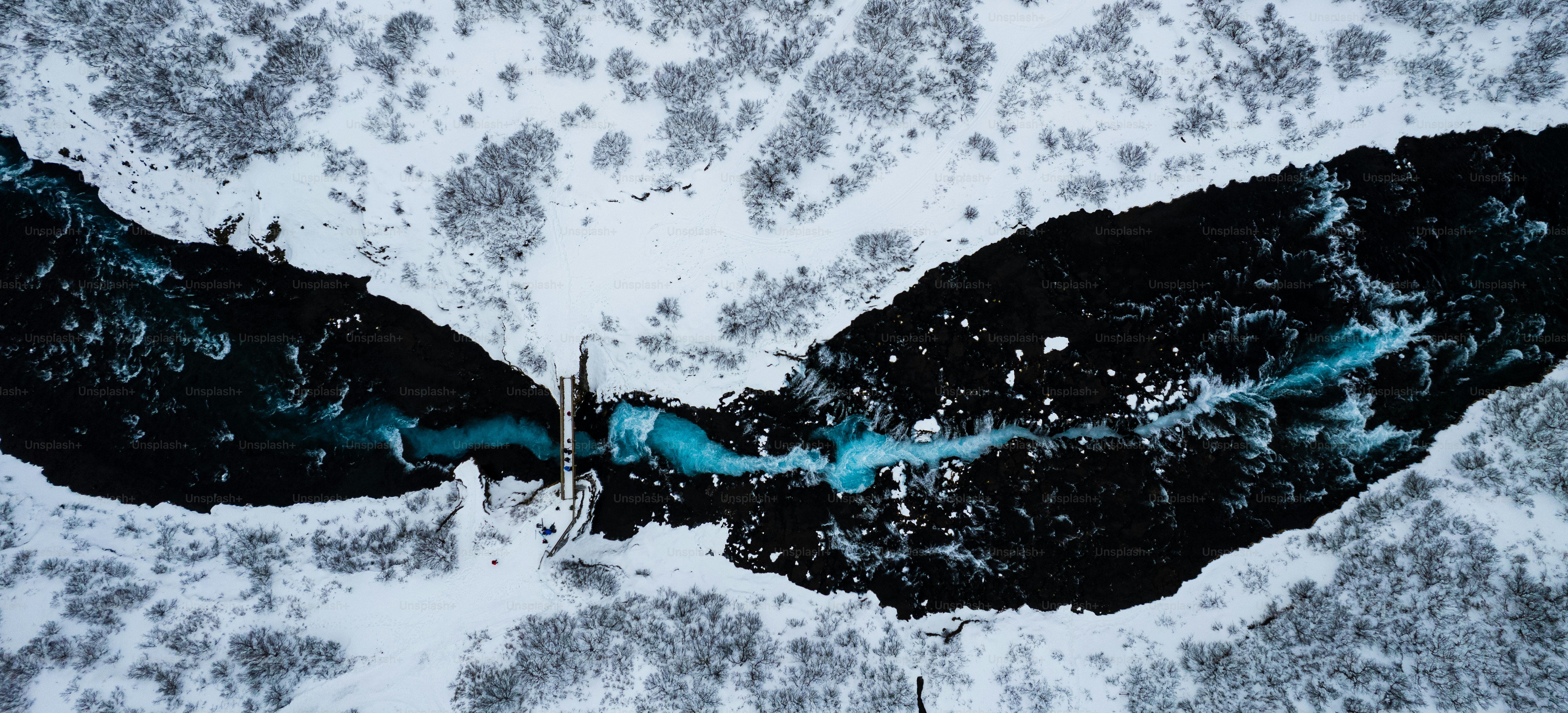 an aerial view of a river in the snow