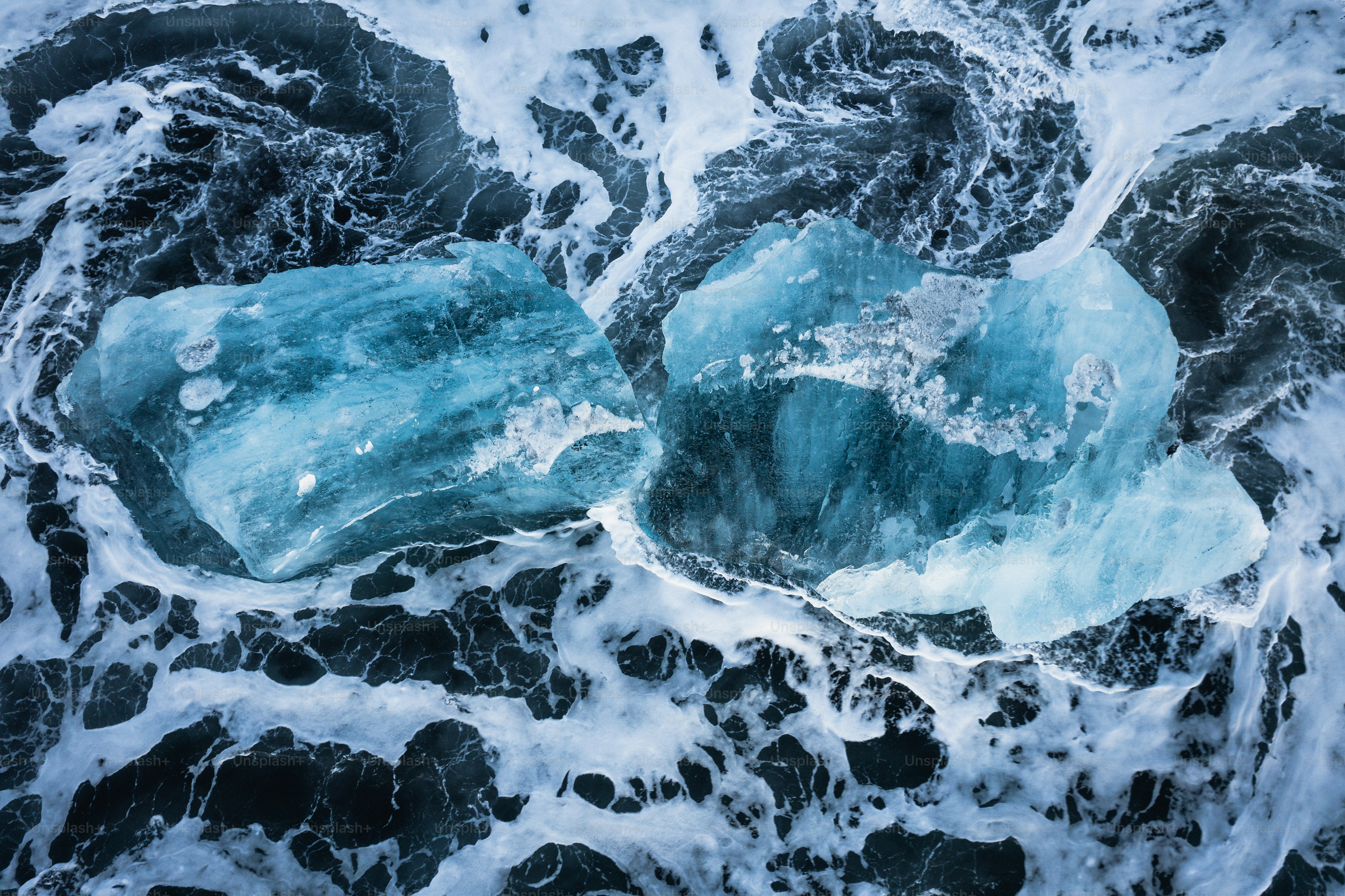 two pieces of ice floating on top of a body of water