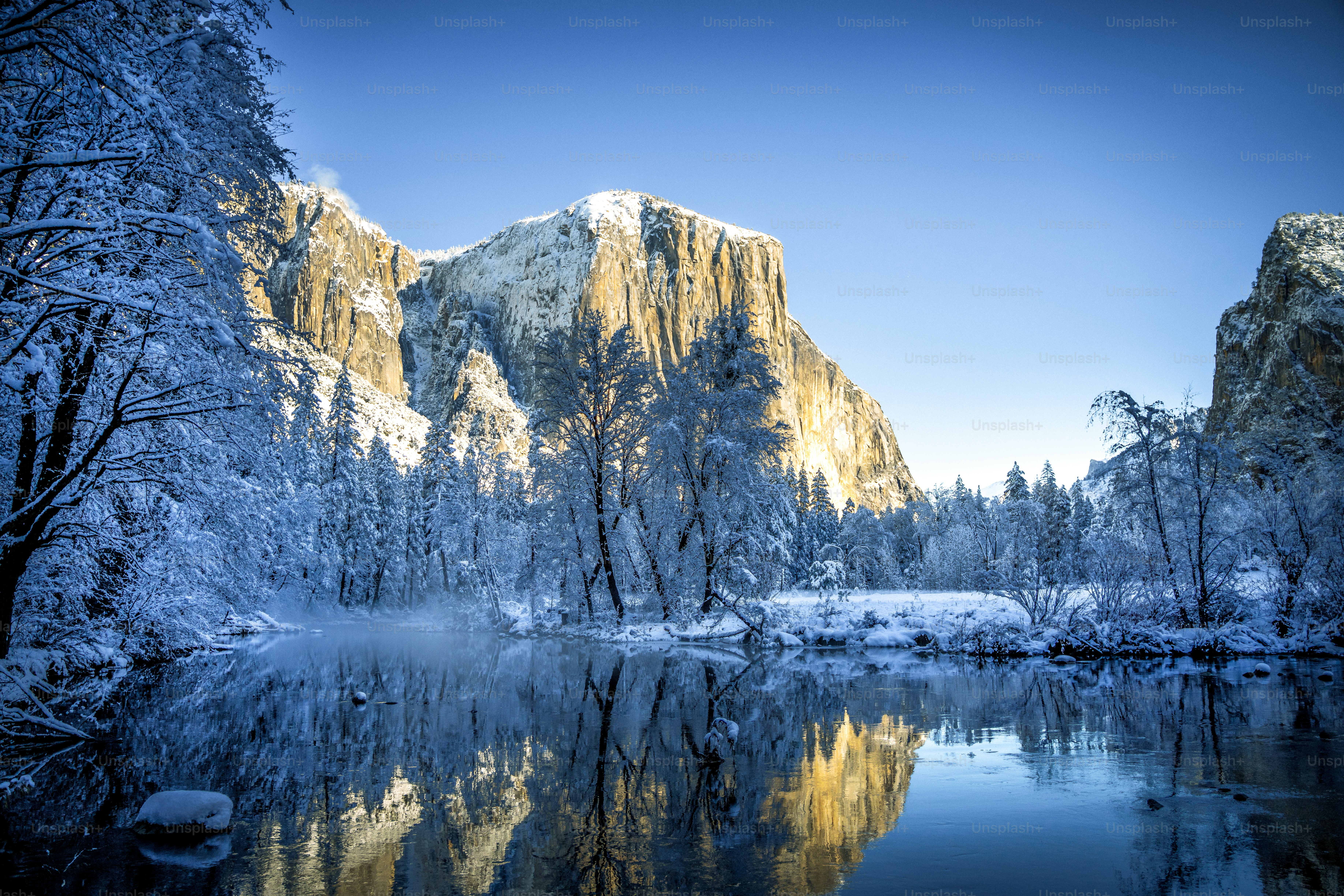 Un lago circondato da montagne e alberi innevati