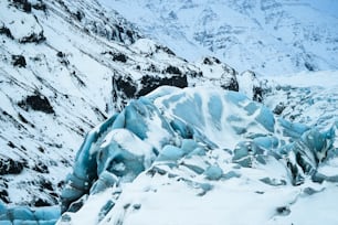 a snow covered mountain side with a bunch of ice on it