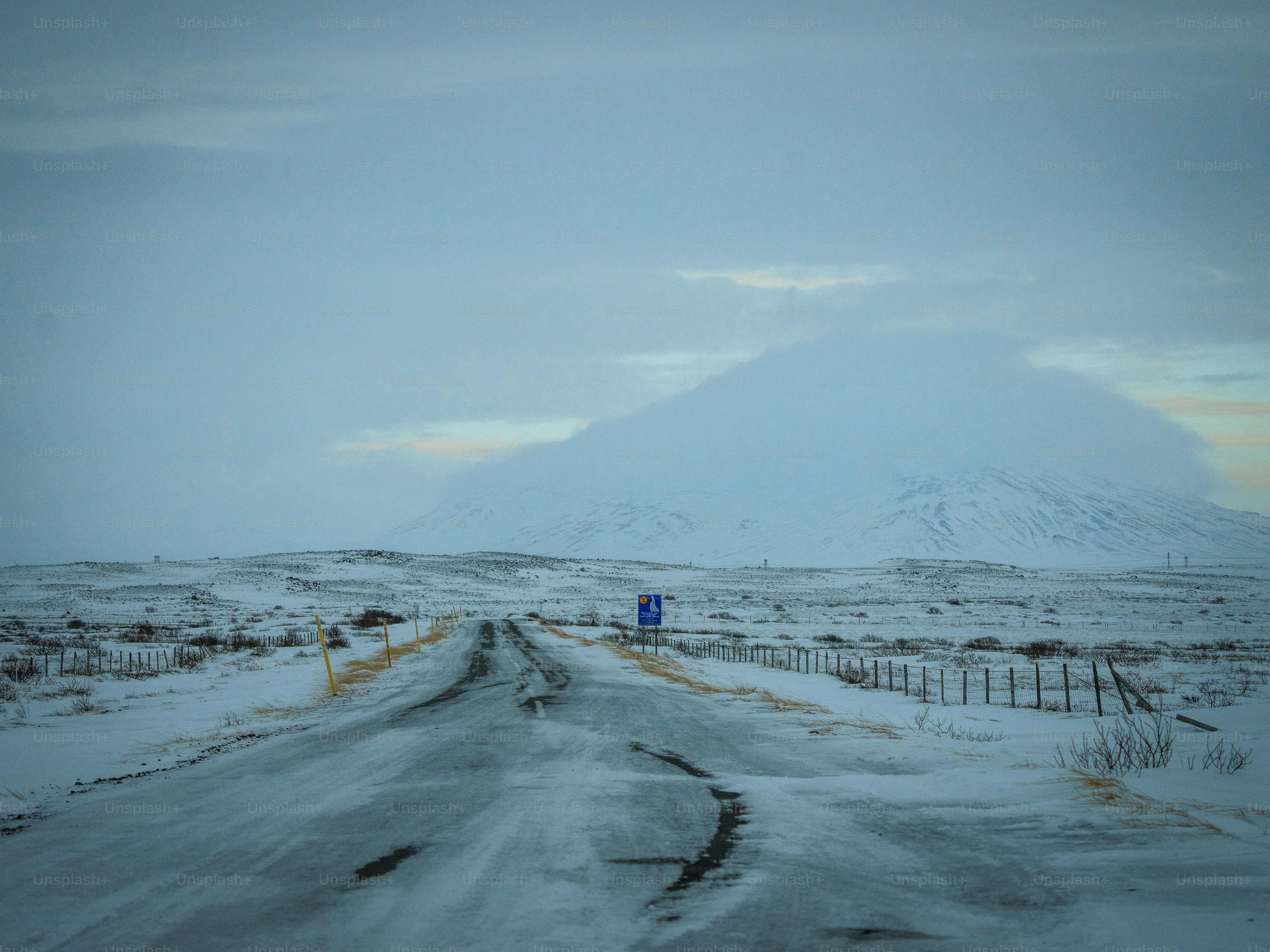 A snow covered road with a mountain in the background photo – Iceland ...