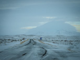eine schneebedeckte Straße mit einem Berg im Hintergrund
