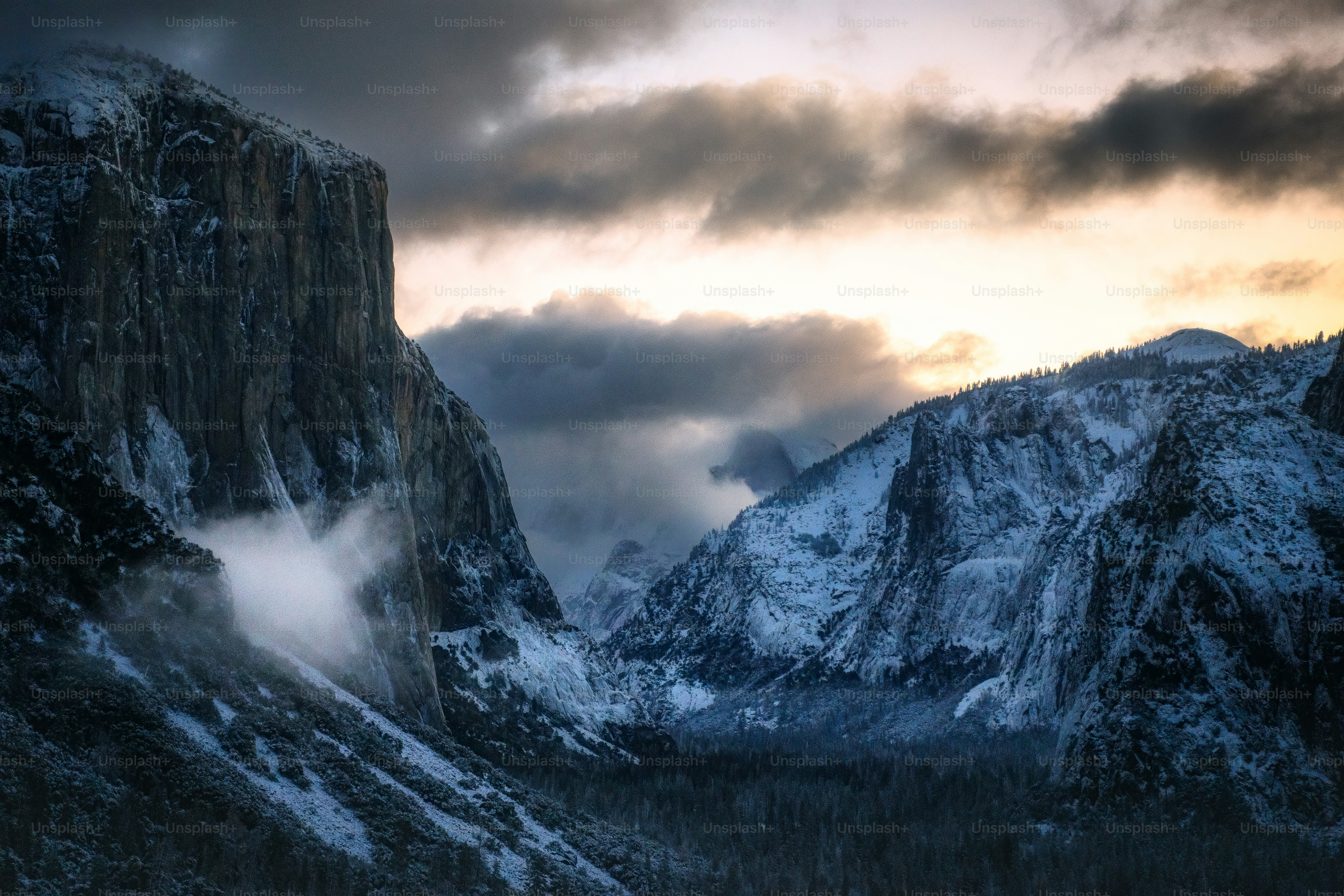 a mountain covered in snow under a cloudy sky