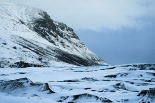 Ein schneebedeckter Berg mit blauem Himmel im Hintergrund