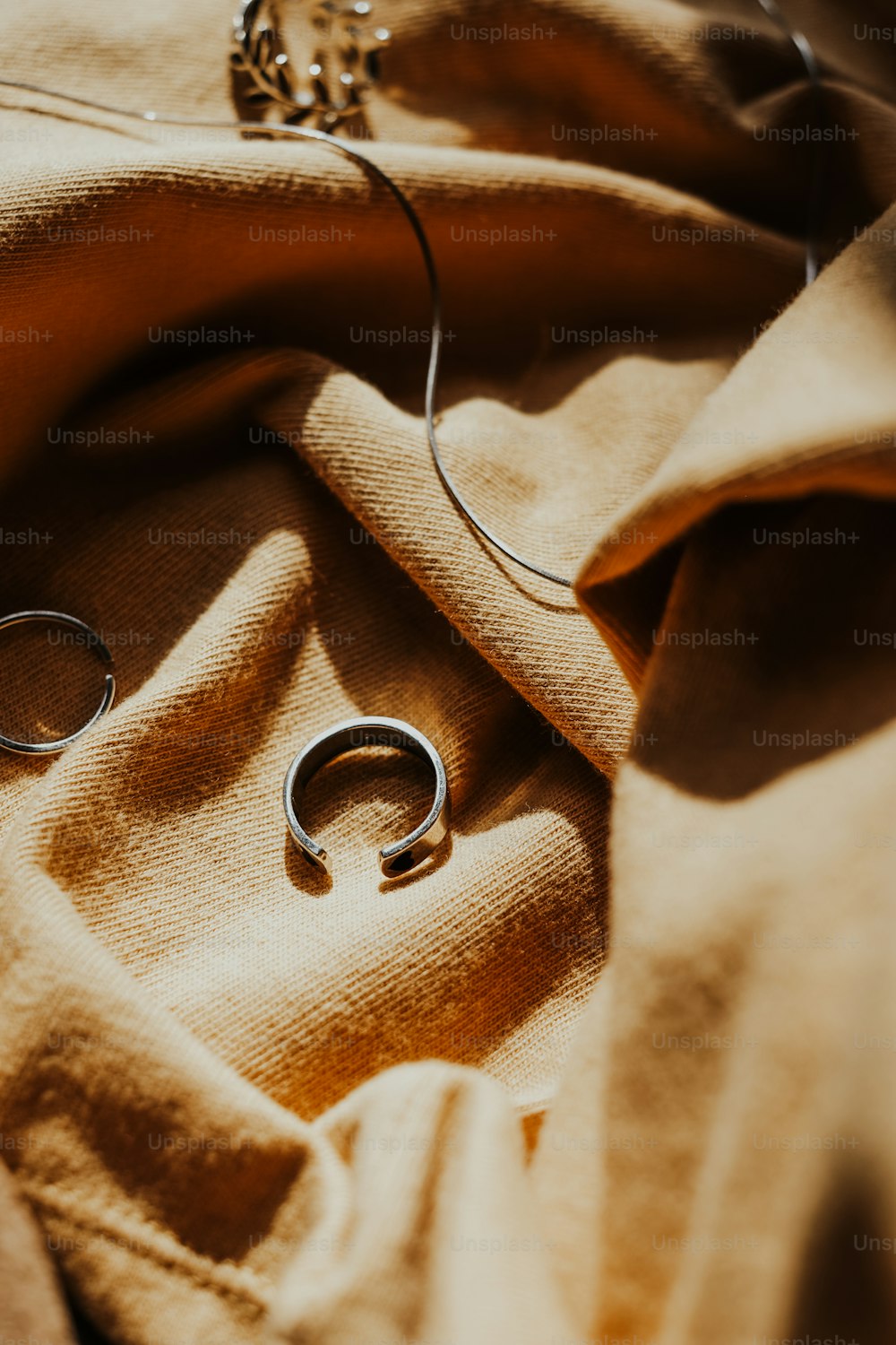 a pair of silver rings sitting on top of a blanket
