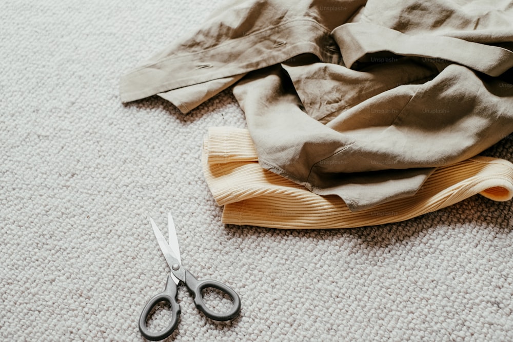 a pair of scissors laying on the floor next to a cloth