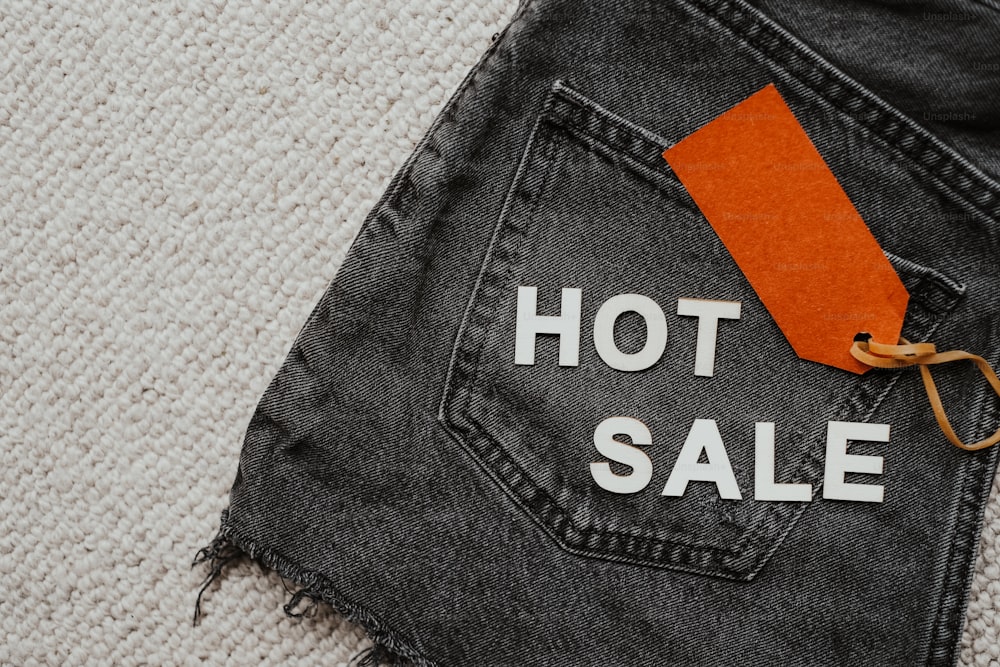um par de jeans com uma etiqueta de venda quente sobre ele