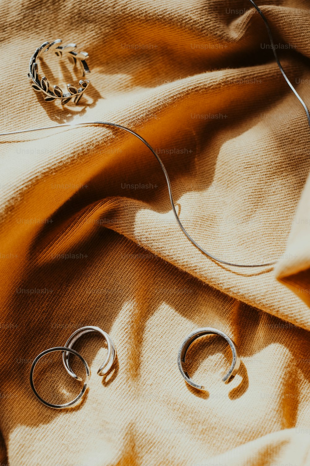 Un par de anillos de plata sentados encima de una manta