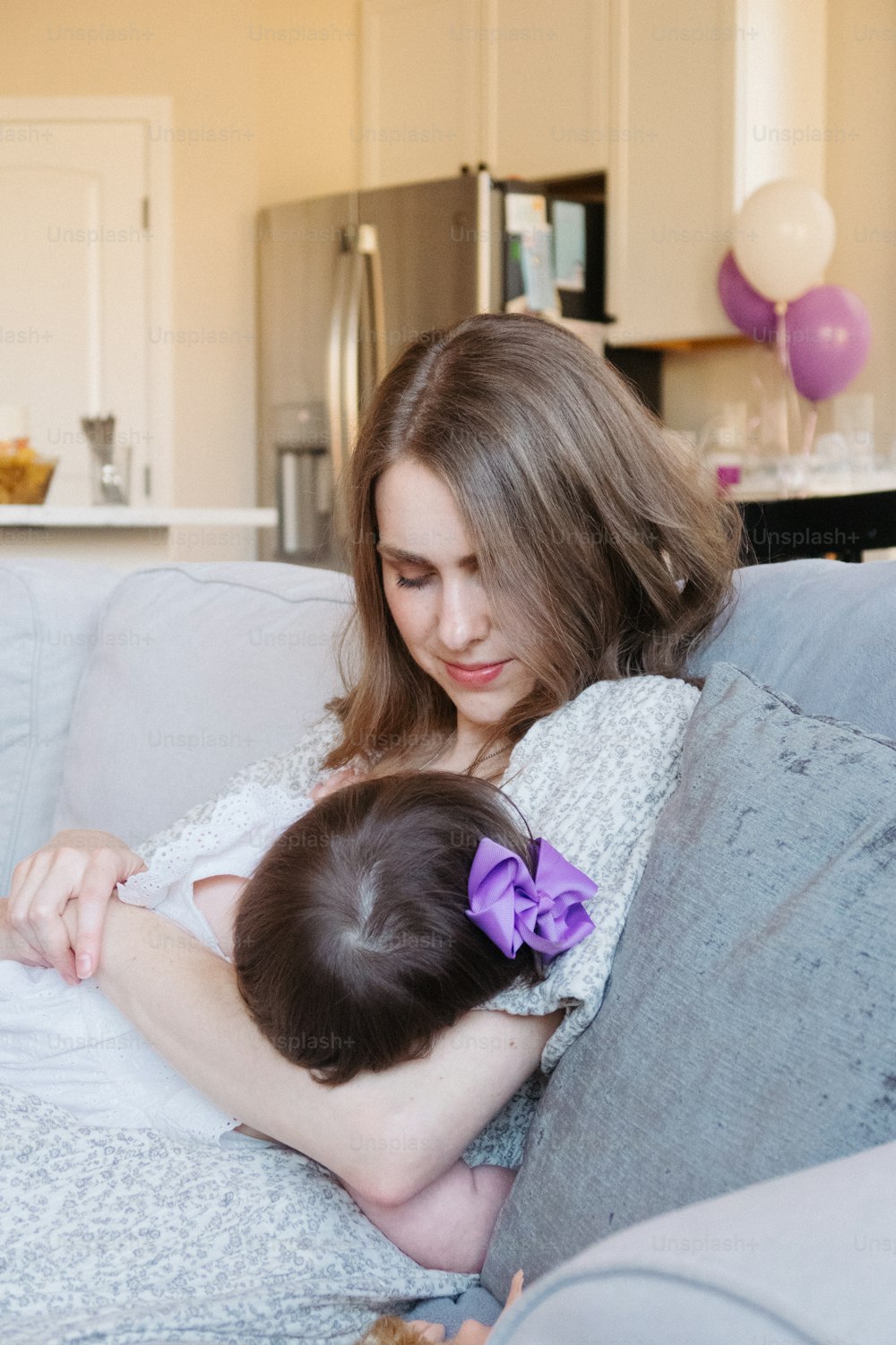 a woman holding a baby wrapped in a blanket