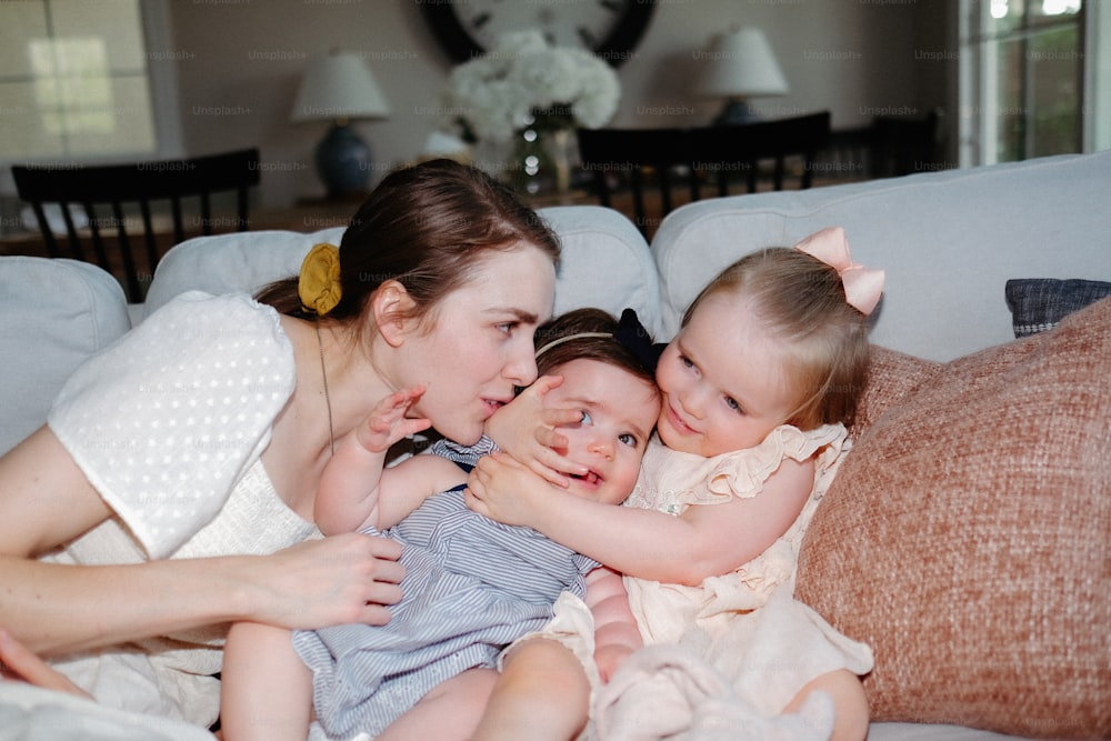 a woman laying on a couch with two babies
