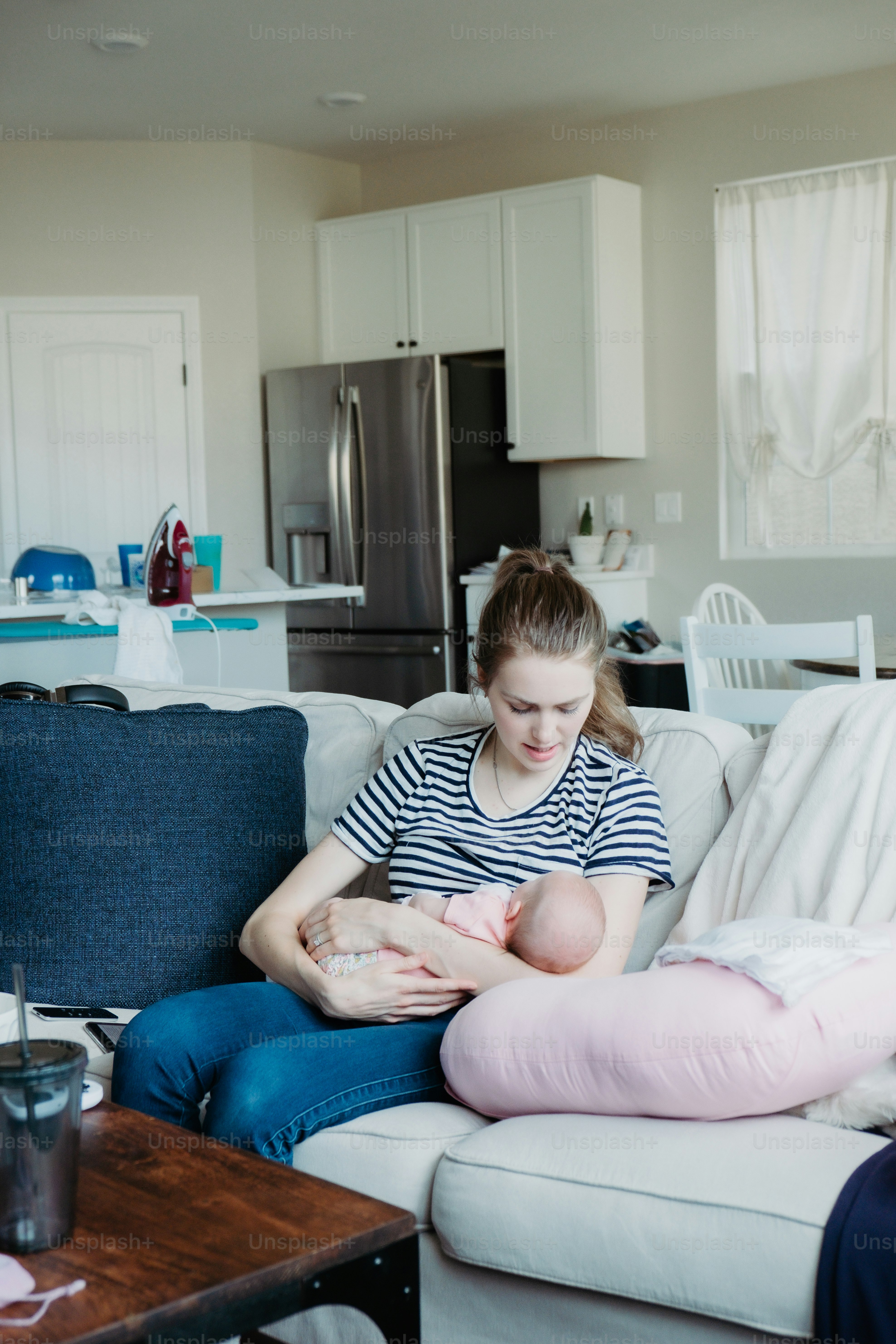 a woman sitting on a couch holding a baby
