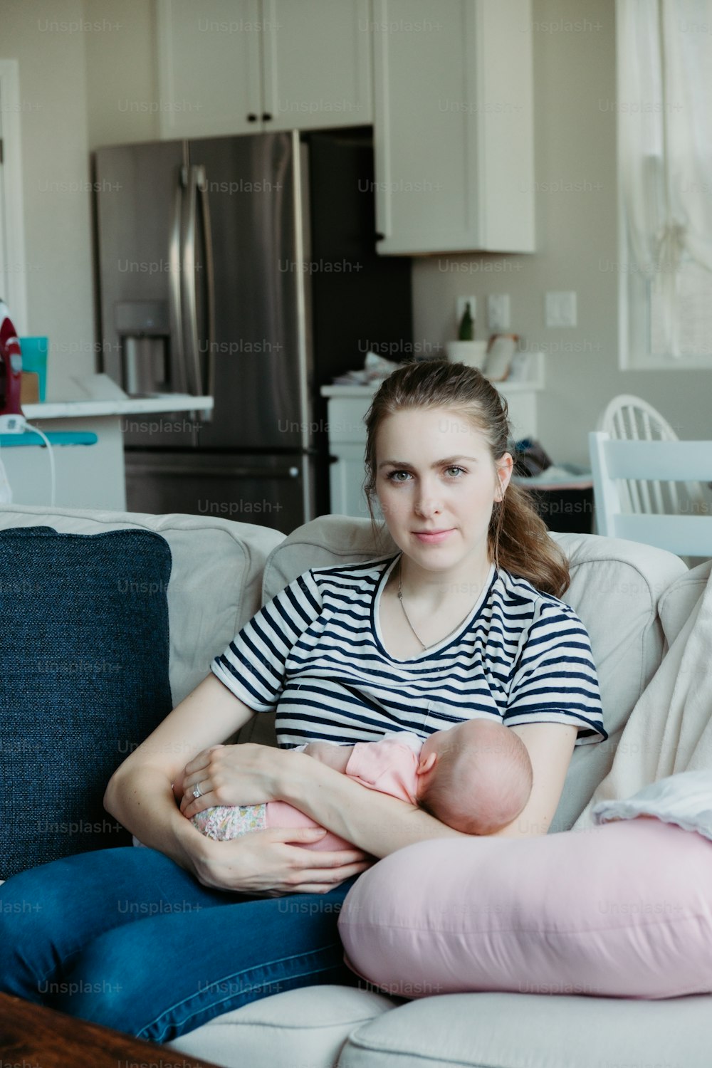 uma mulher sentada em um sofá segurando um bebê