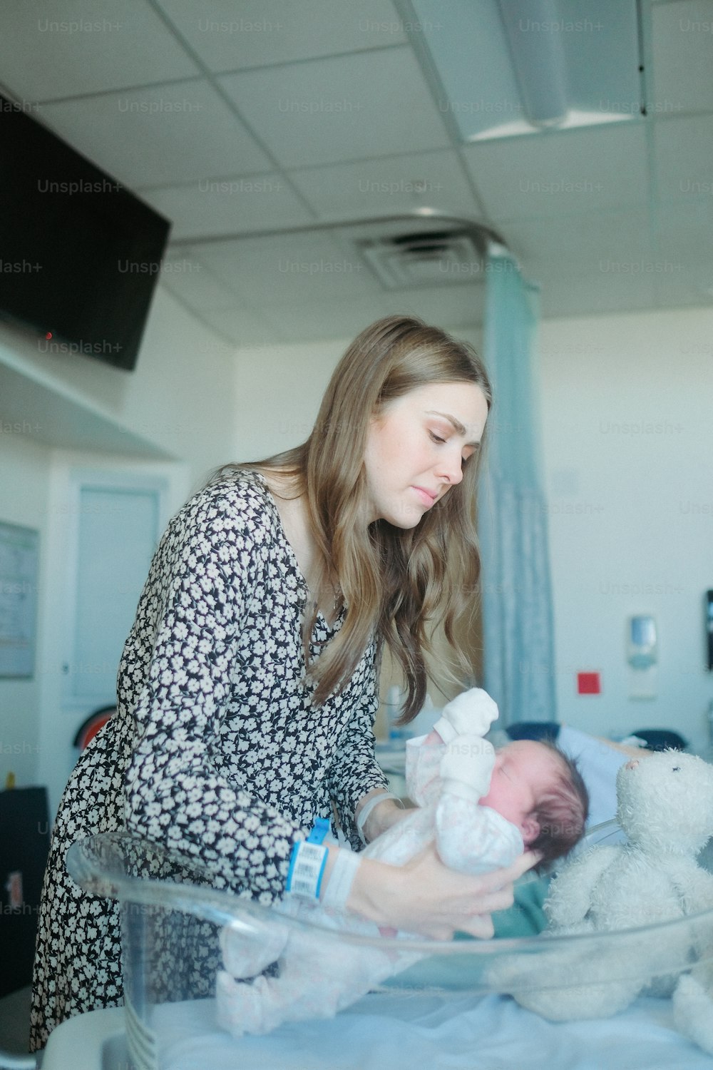病院のベッドで赤ちゃんを抱く女性