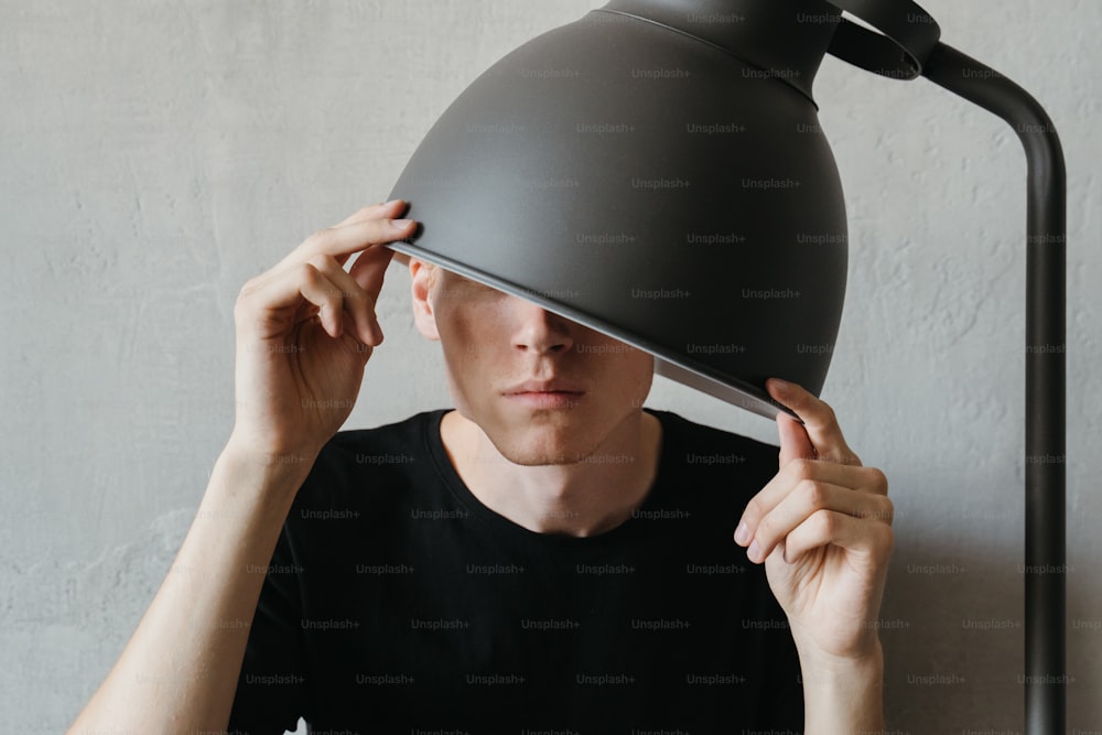 um homem segurando uma lâmpada sobre a cabeça