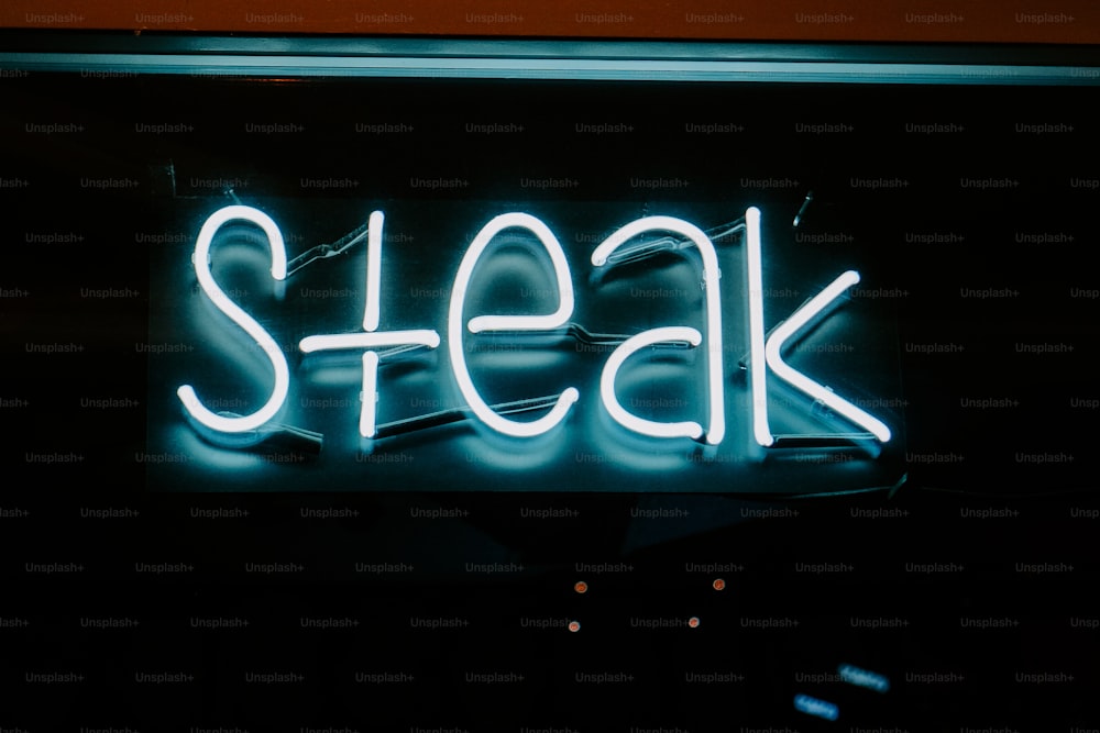 une enseigne au néon qui dit steak dessus