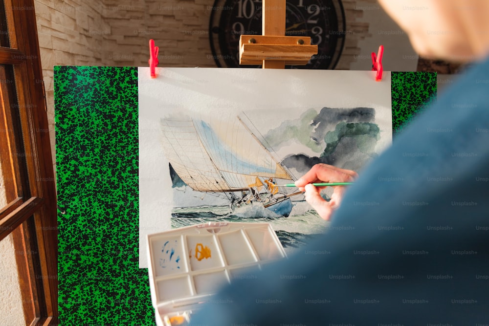 una persona sta dipingendo un quadro su un cavalletto