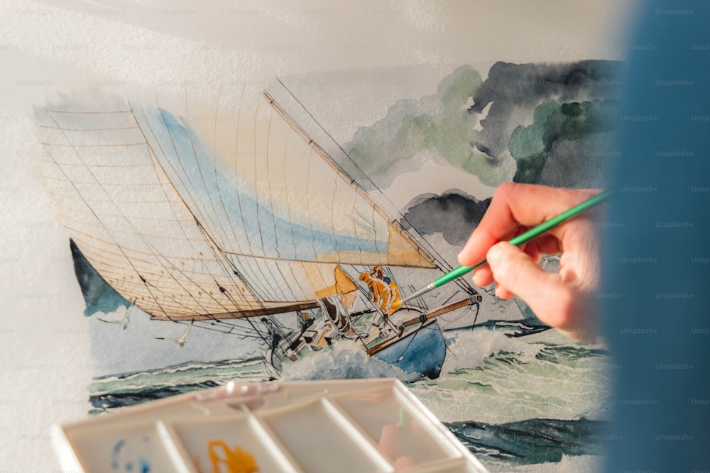 Una persona está pintando un velero en una pared