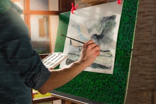 Un hombre está pintando un cuadro en un lienzo
