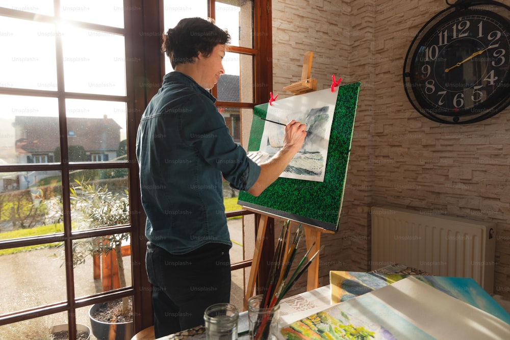 a man standing in front of a painting on a easel