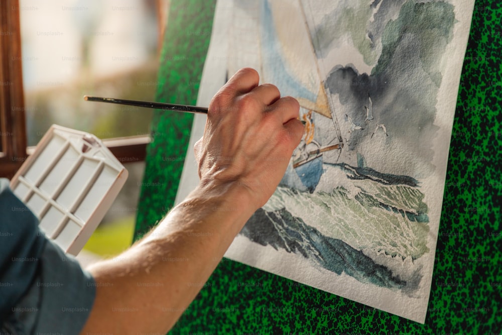 Un hombre está pintando un cuadro con un pincel