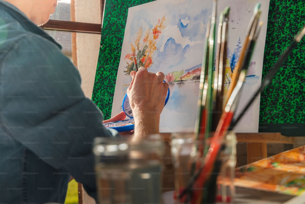a woman is painting a picture in an art studio