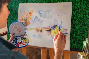 une personne peint un tableau avec des aquarelles