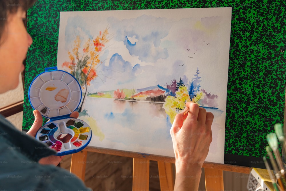 Una persona sta dipingendo un quadro con acquerelli