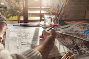 uma pessoa sentada em uma mesa com alguns suprimentos de arte