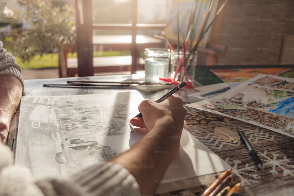 a person sitting at a table with some art supplies