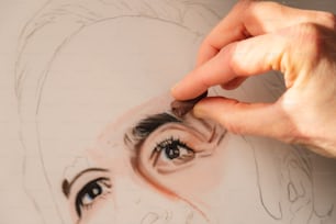 a person drawing a woman's face with a pencil