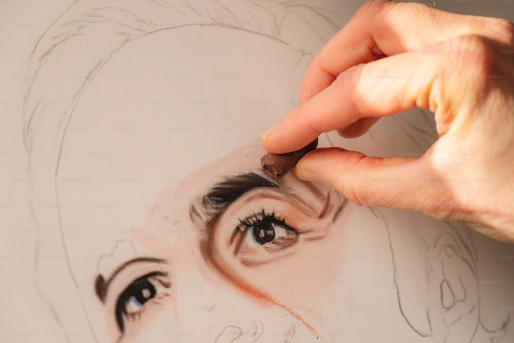 a person drawing a woman's face with a pencil