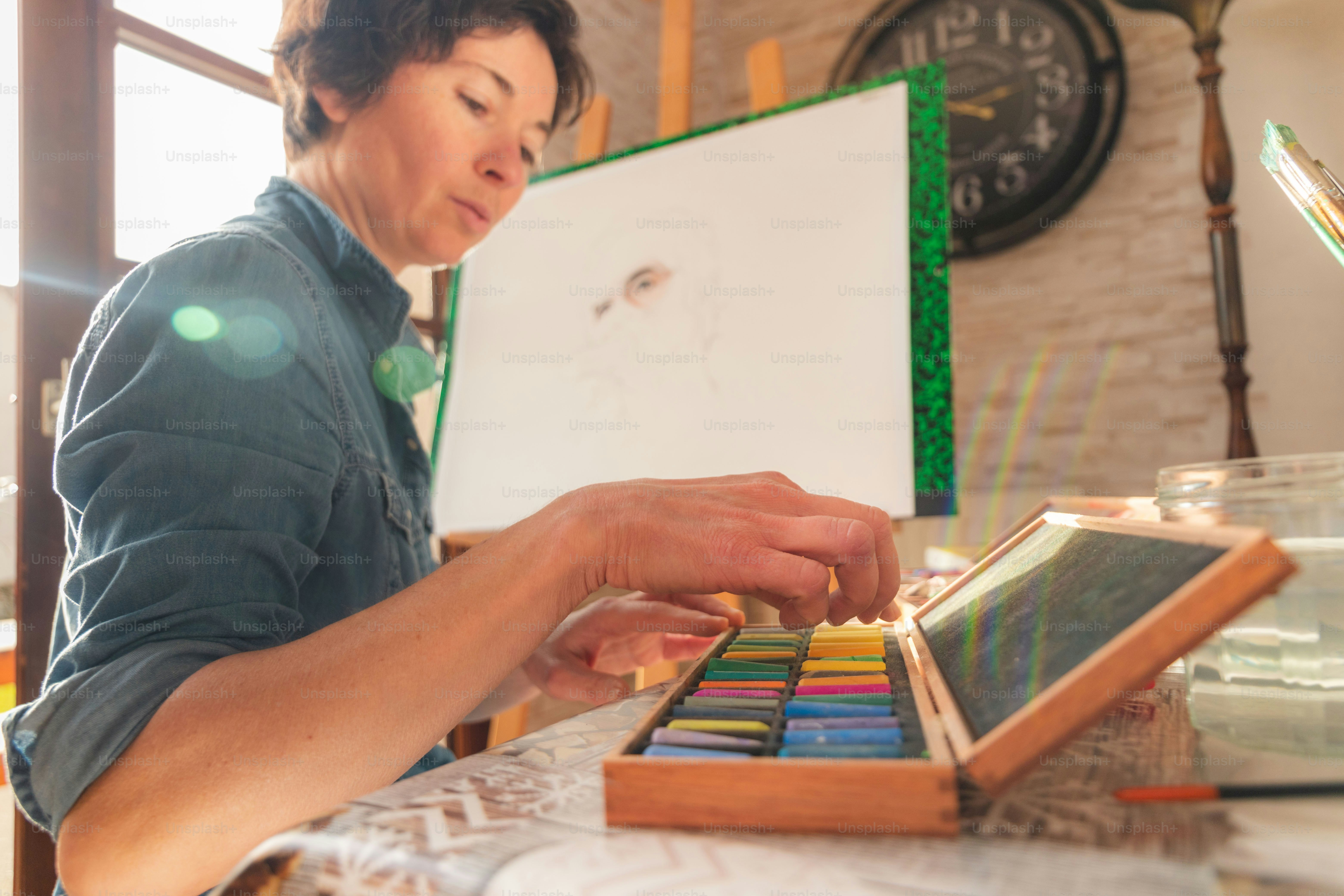 Eine Frau arbeitet an einem Kunstprojekt mit Buntstiften