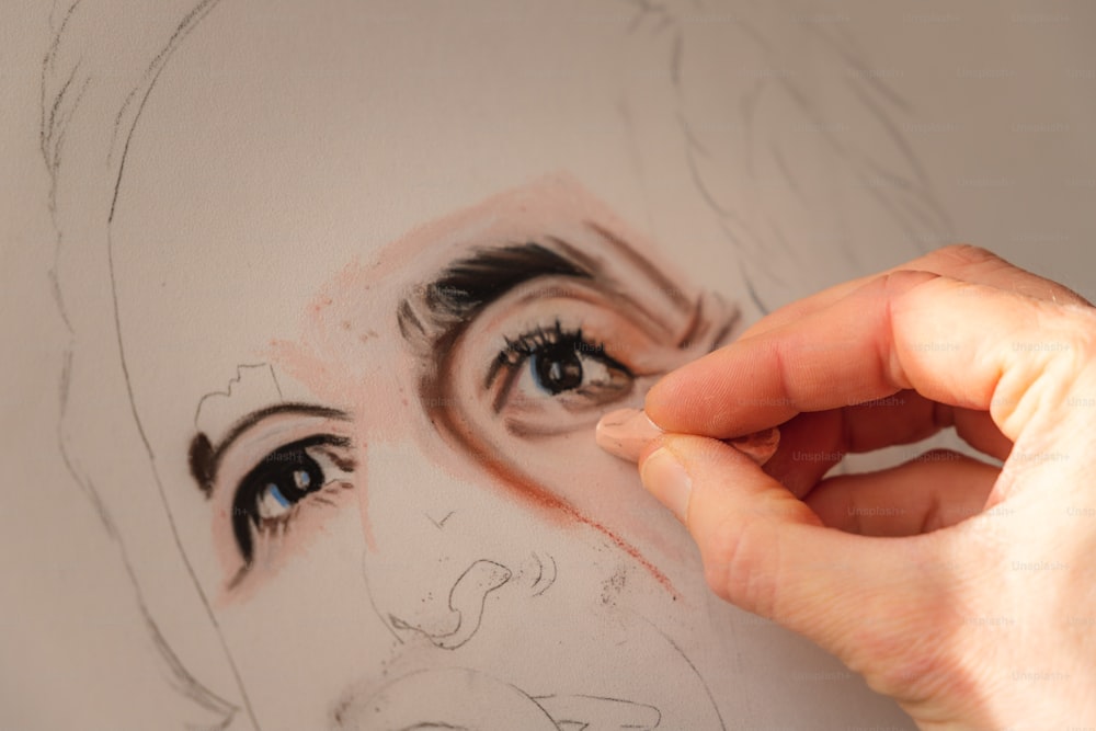 a person drawing a woman's face with a pencil