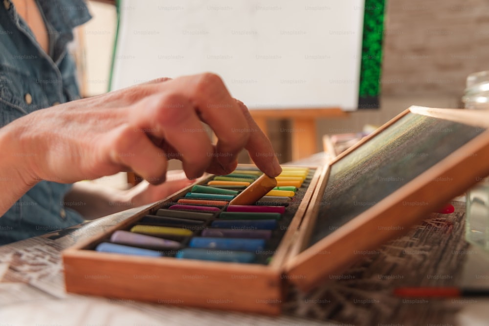 a person holding a box of colored pencils