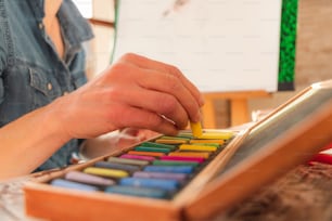 a person using a pencil to draw on a piece of wood