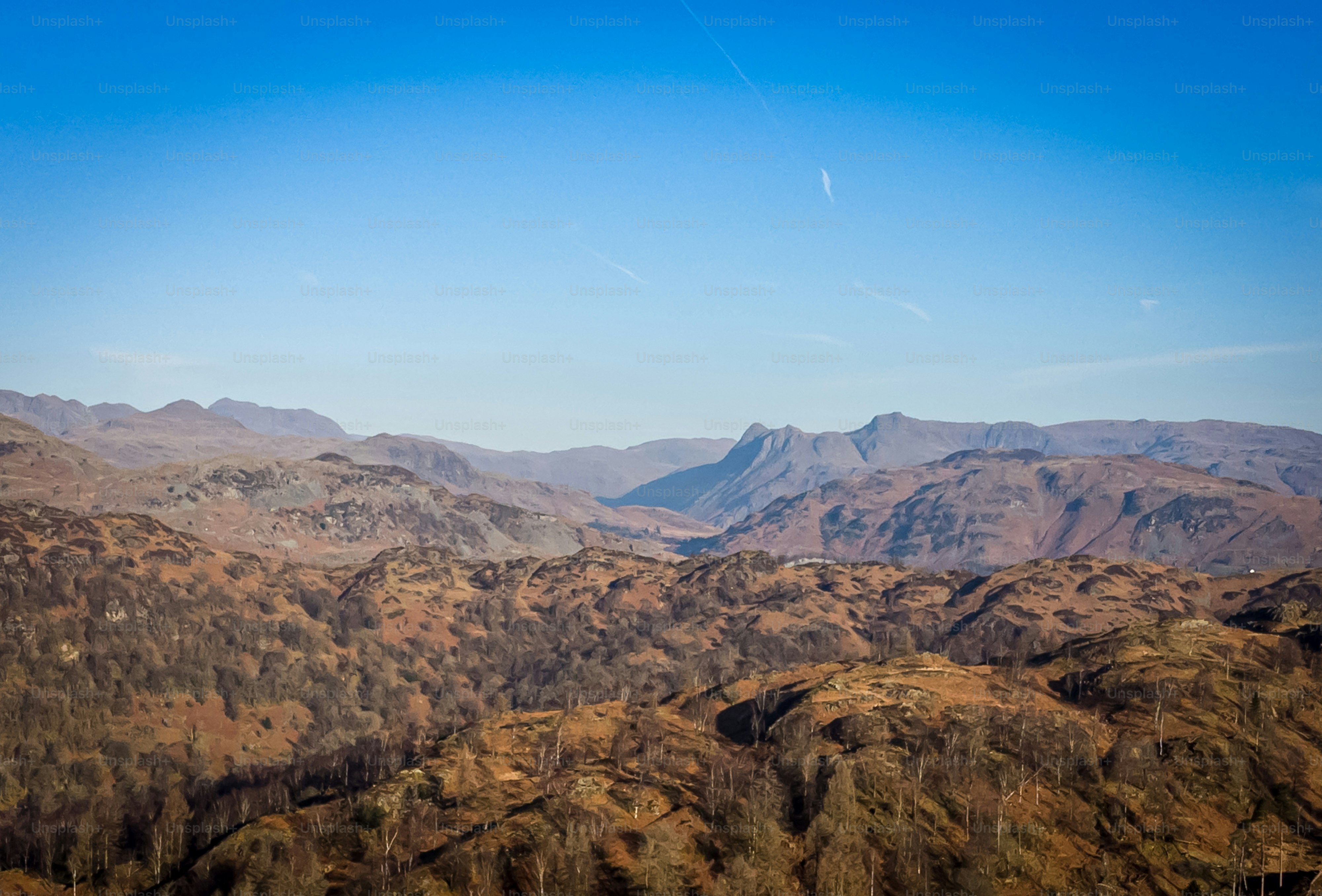 a view of a mountain range with a plane flying in the sky