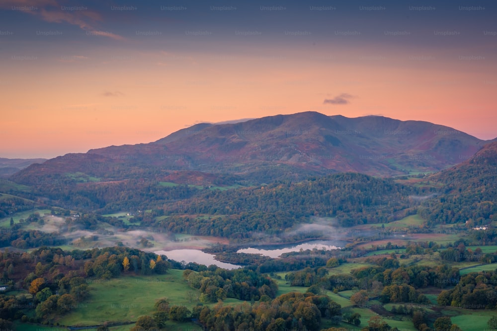 a scenic view of a mountain range with a lake in the foreground