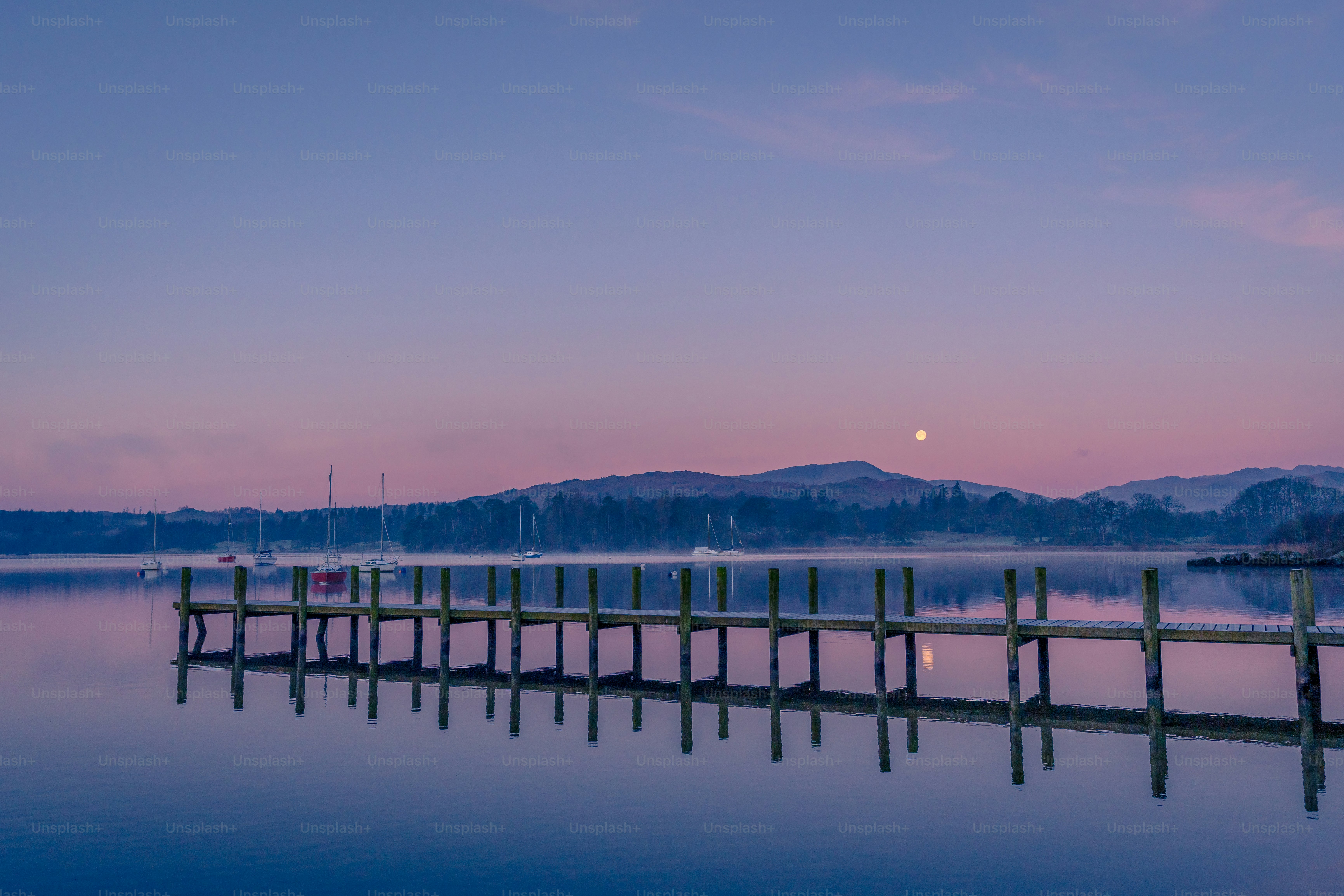 a dock on a lake with mountains in the background