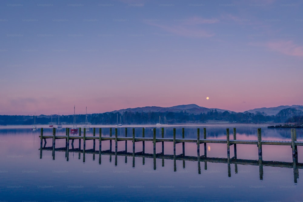 a dock on a lake with mountains in the background