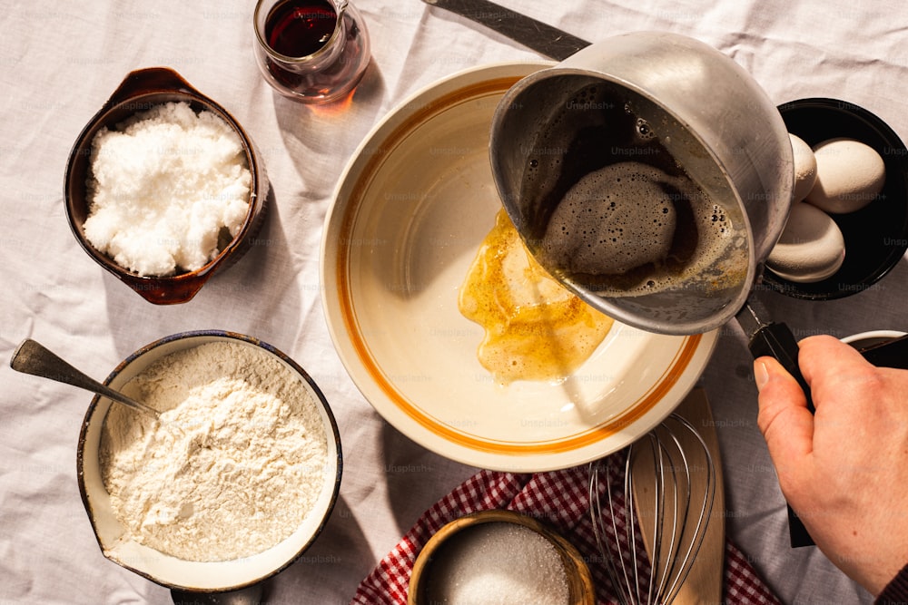 a person pours flour into a bowl