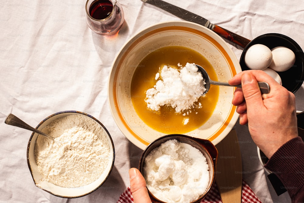 a person mixing ingredients in a bowl on a table