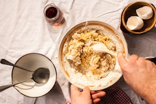 a person mixing food in a bowl on a table