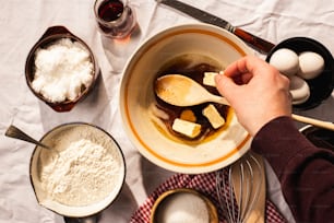 a person mixing ingredients in a bowl on a table