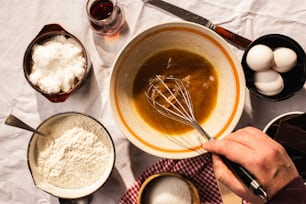 a person mixing ingredients in a bowl on a table