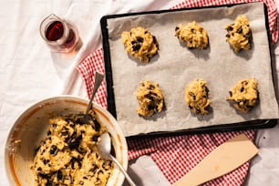 a pan filled with cookies next to a glass of wine