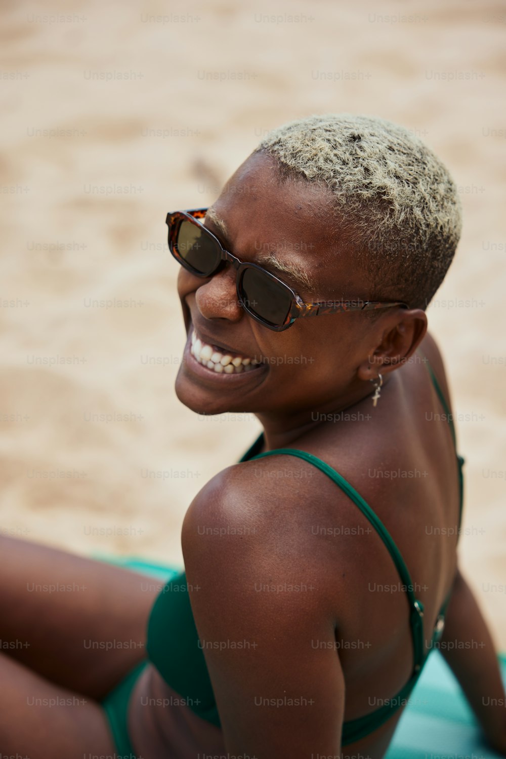 Eine Frau im Bikini sitzt am Strand