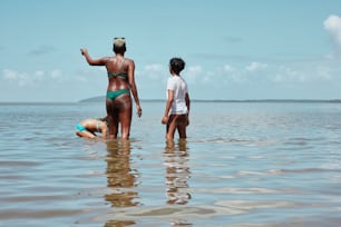 a woman in a bikini standing next to a man in the water