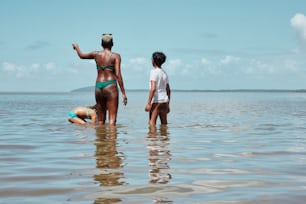 Una mujer en bikini de pie junto a un hombre en el agua